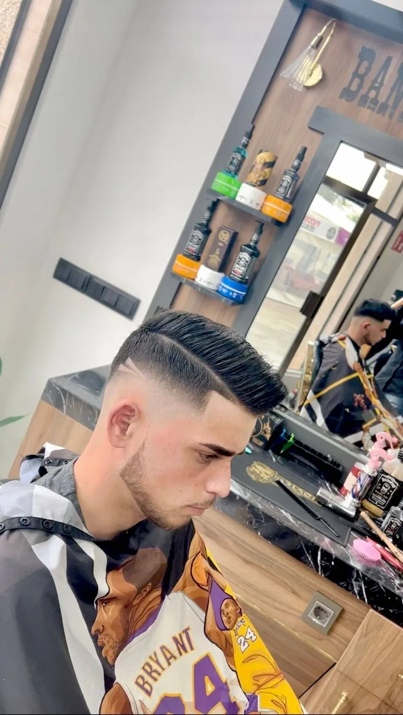 Cliente con degradado en los lados y el pelo de arriba peinado hacia atrás con volumen