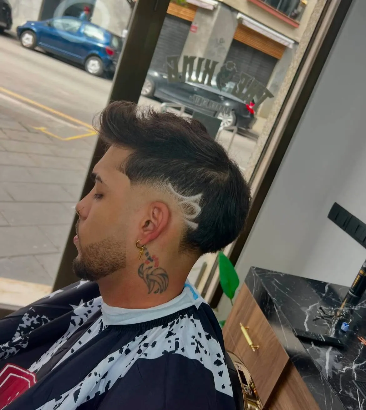 Perfil de un cliente con degradado, raya en el lateral y el pelo de arriba peinado